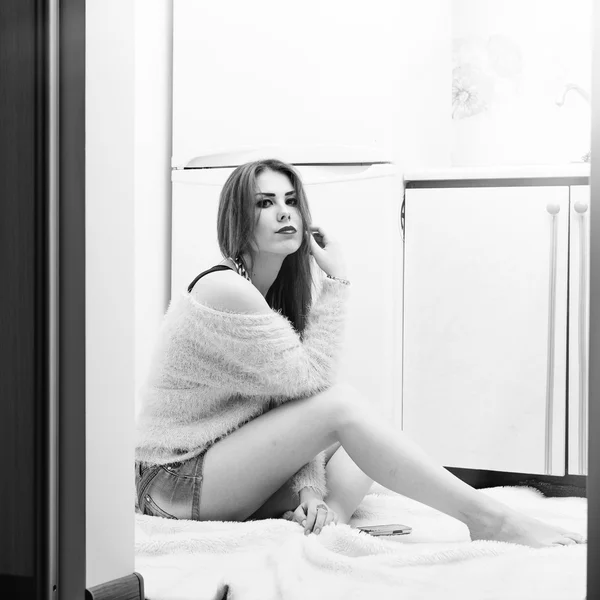Фото красивой молодой леди, сидящей на полу на кухне, расслабляясь возле холодильника и копировального фона — стоковое фото
