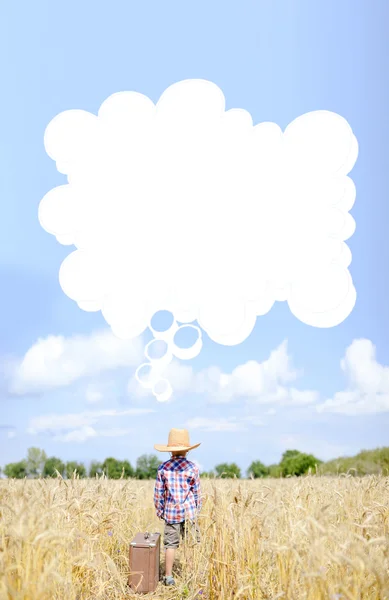 Niño pequeño al lado valize con burbuja de pensamiento en el campo de verano — Foto de Stock