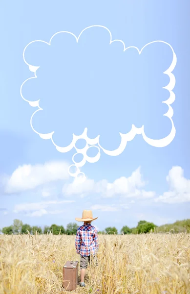 Niño pequeño al lado valize con burbuja de pensamiento en el campo de verano — Foto de Stock