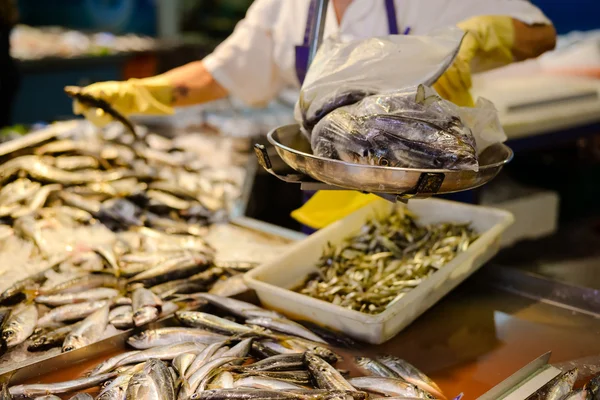 Prodejci ruce v žluté rukavice Vážení čerstvých ryb v trhu — Stock fotografie