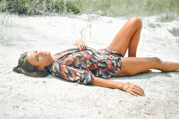 Молода жінка лежить влітку на пляжі — стокове фото