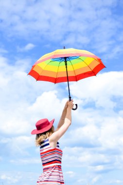 Picture of beautiful elegant female with rainbow umbrella on sunny day and blue sky background