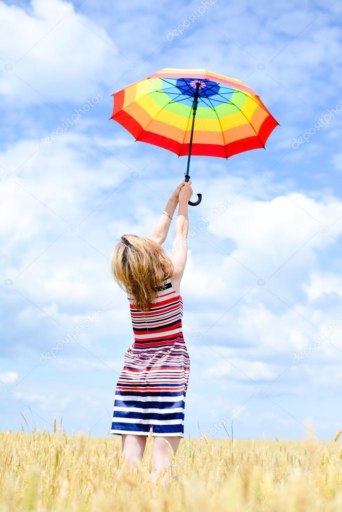 Image of elegant romantic woman having fun holding up umbrella on blue sky copy space background outdoors