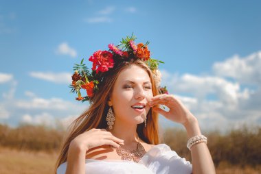 Beautiful young lady in marigold wreath and necklace in countryside