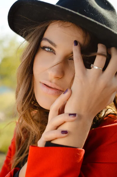 Hermosa joven con sombrero y abrigo rojo en otoño — Foto de Stock