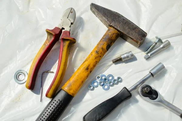 Marteau et autres outils de réparation utilisés sur fond plastique blanc — Photo