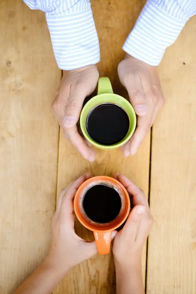 Top view of man and womans hands holding two coffeemugs