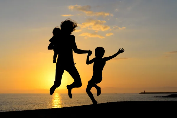 Silhouette of exciting woman with children having fun in sunset sunlights — Stock Photo, Image