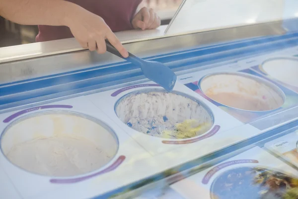 Présentoir de magasin avec différents types de crème glacée et vendeurs main — Photo