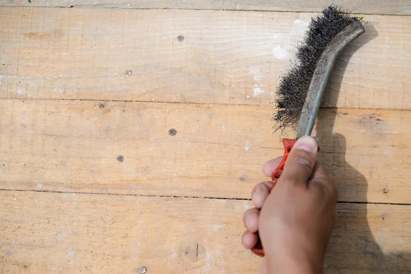 Fechar de esfregar e limpar com escova de metal em madeira — Fotografia de Stock