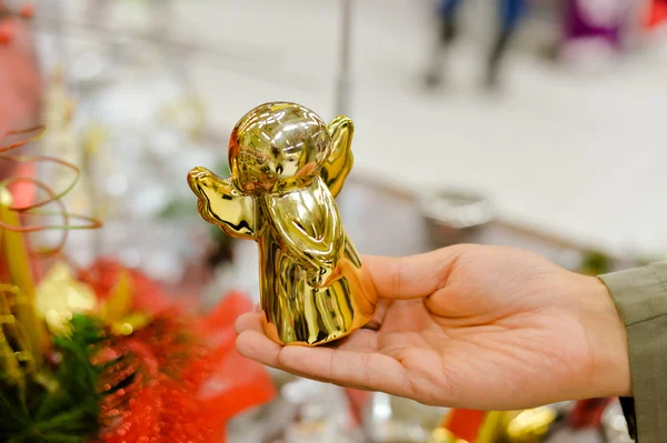 Closeup of hand holding golden christmas angel ornament in store — Stock Photo, Image