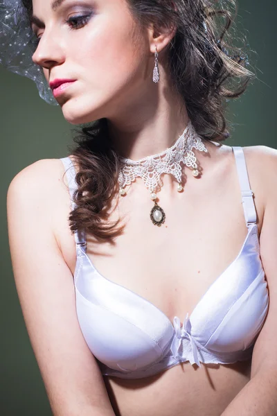 Beautiful young woman in bra and pearl necklace, close up portrait — Stockfoto