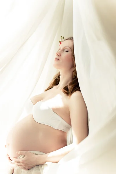 Immagine di incinta bella giovane donna su spazio luce copia Foto Stock