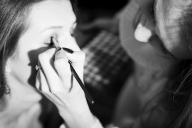 Picture closeup on makeup procedure. Black and white photography