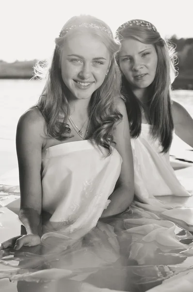 2 beautiful princess young ladies in white dresses on summer water outdoors background, black and white picture — Stockfoto