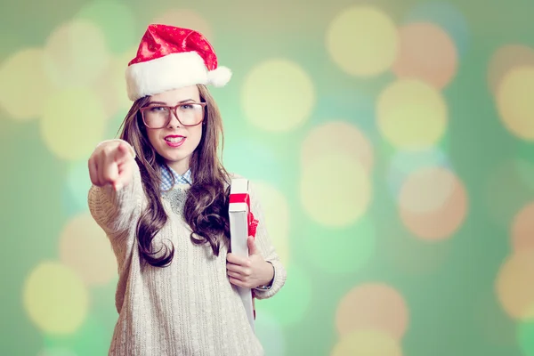 Picture of pointing finger and holding present box beautiful young lady in Santa Claus hat on abstract festive background design — Stock Photo, Image