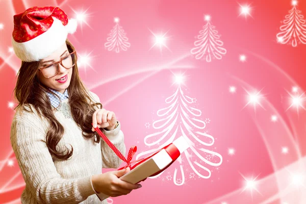 Menina bonita romântica feliz em Santa chapéu vermelho e óculos de abertura caixa de presente no design de fundo festivo abstrato — Fotografia de Stock