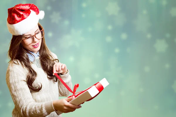 Bella ragazza in cappello rosso Santa e bicchieri apertura confezione regalo — Foto Stock