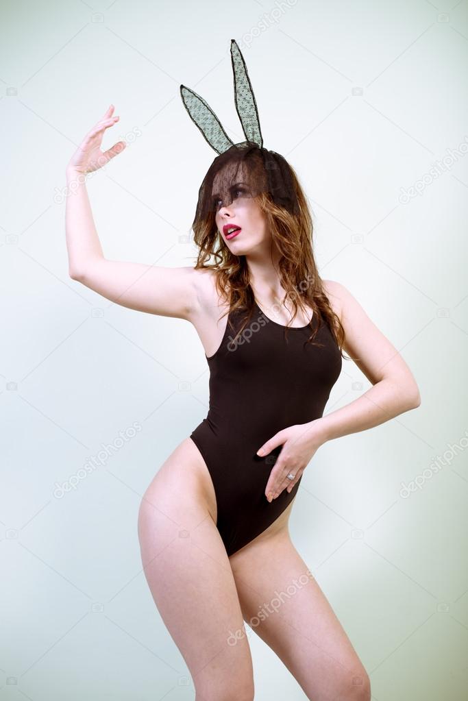 Posing Sexy Play Girl In Bunny Costume Against White Background