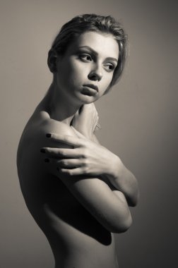 Portrait of beautiful sexy young lady looking aside covering her naked shoulder standing posing on copy space background clipart