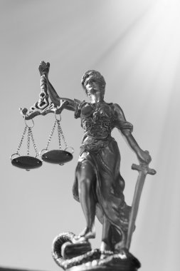 Black and white picture of sculpture of themis, femida or justice goddess on bright blue sky outdoors copy space background