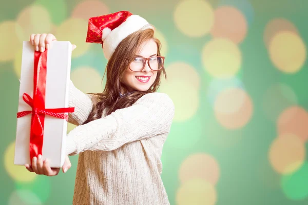 Beautiful young woman in Santa red hat and glasses showing gift box — Stockfoto