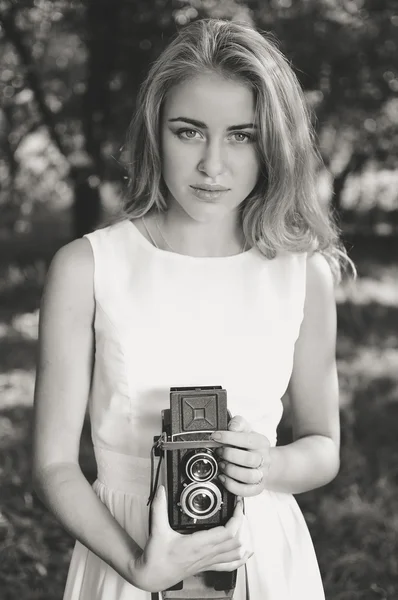 Joven hermosa mujer rubia con cámara retro retrato en blanco y negro en el fondo de la naturaleza —  Fotos de Stock