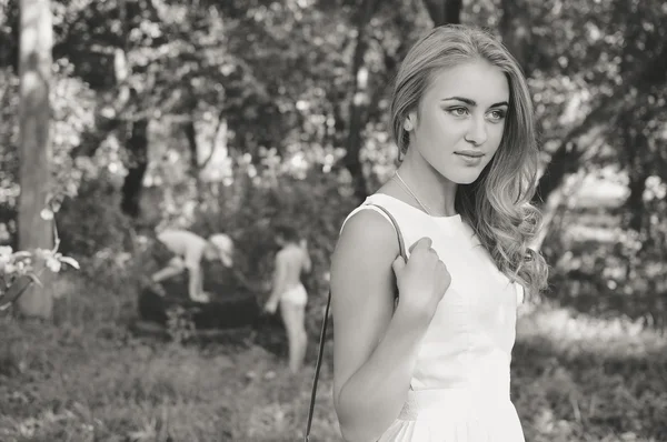 Portrait noir et blanc de belle jeune femme blonde en fond nature d'été — Photo