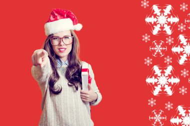 Portrait of pointing finger and holding present box beautiful young lady in Santa Claus hat on abstract festive background design