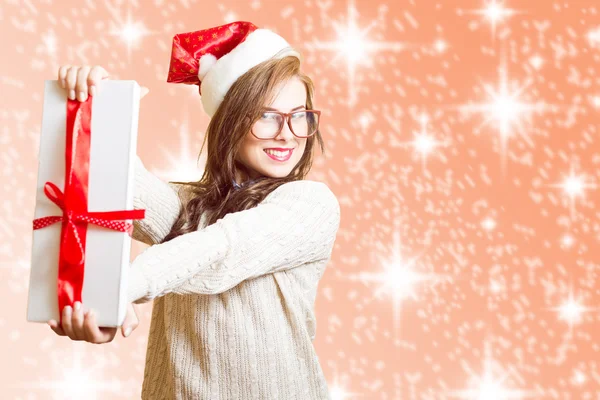 Bild zeigt Geschenkbox schöne junge Frau mit Weihnachtsmann roten Hut und Brille — Stockfoto