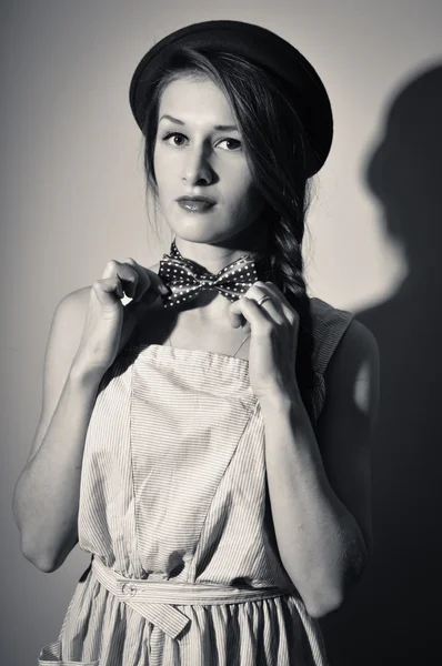 Beautiful girl in hat and bow tie looks surprised. Black and white photography — Stock Fotó