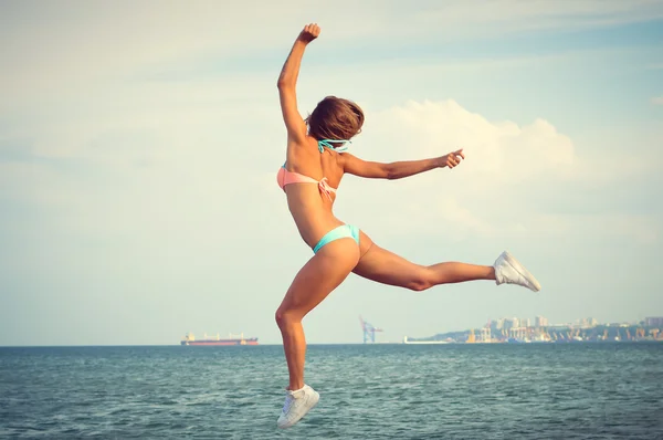 Retrato de hermosa mujer joven divirtiéndose en salto de altura sobre el espacio de copia de fondo al aire libre — Foto de Stock