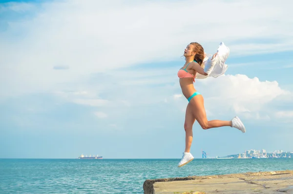 Retrato de hermosa mujer joven divirtiéndose en salto de altura sobre el espacio de copia de fondo al aire libre — Foto de Stock