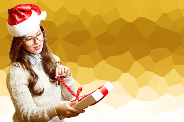 Beautiful girl in Santa red hat and glasses opening gift box — Stockfoto