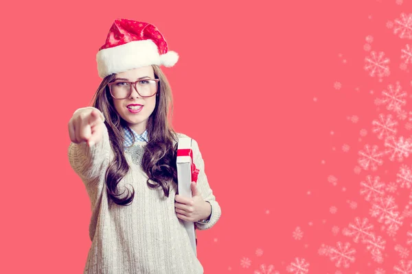 Apontando o dedo e segurando presente caixa bela jovem senhora em chapéu de Papai Noel em abstrato design de fundo festivo — Fotografia de Stock