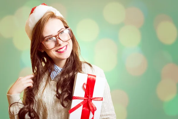 Immagine di bella giovane signora in cappello rosso Santa e bicchieri con scatola regalo — Foto Stock