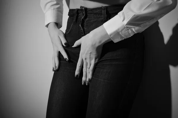 Seducente donna che indossa jeans a maniche lunghe corti e pantaloni su sfondo chiaro. Fotografia in bianco e nero — Foto Stock