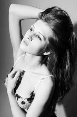 Black and white photography of sexy beautiful young woman in lingerie sensually posing and looking up at copy space background
