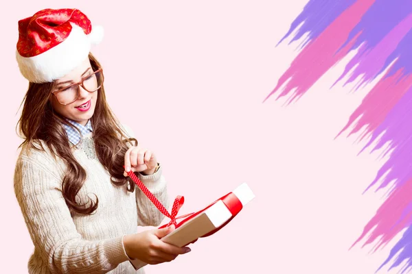 Picture of beautiful girl in Santa red hat and glasses opening gift box — Stok fotoğraf