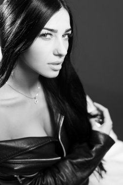 Sexy pretty young lady wearing leather jacket sensually looking at camera. Black and white photography