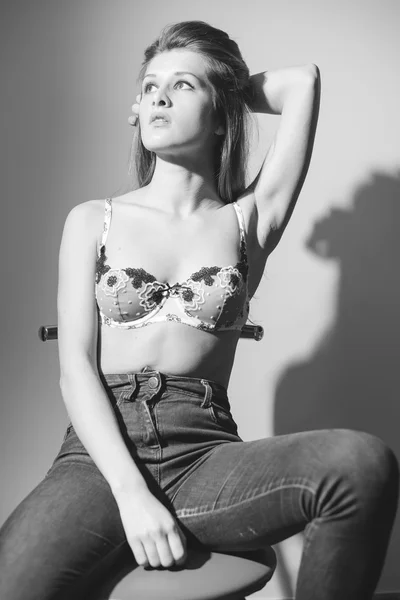Sexy schöne junge Frau in Dessous und Jeans sinnlich posiert und Blick auf Kopierraum Hintergrund. Schwarz-Weiß-Bild — Stockfoto