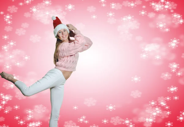 Excited lady in Santa hat jumping up on pink background — Stockfoto