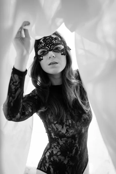 Фото молодой красивой леди с идеальным телом в черных комбинезонах платье и маска, стоящие на свет занавес копировать пространство фона — стоковое фото
