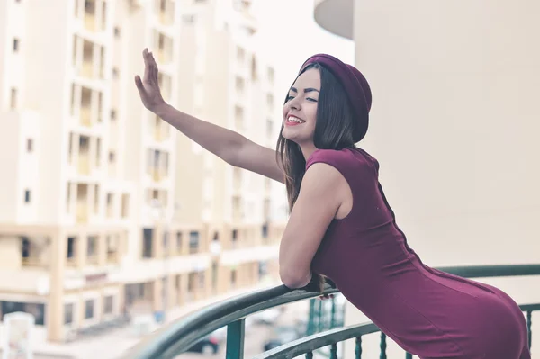 Senhora sorridente elegante de pé na varanda acenando mão cumprimentando alguém — Fotografia de Stock