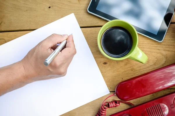 Hand hält Stift und notiert etwas auf weißem Papierblatt — Stockfoto