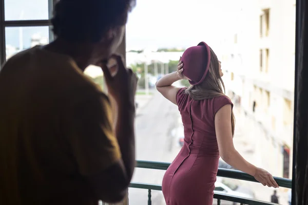 Άνθρωπος θαυμάζοντας την όμορφη κοπέλα στον τοποθετηθεί φόρεμα στέκεται στο μπαλκόνι — Φωτογραφία Αρχείου