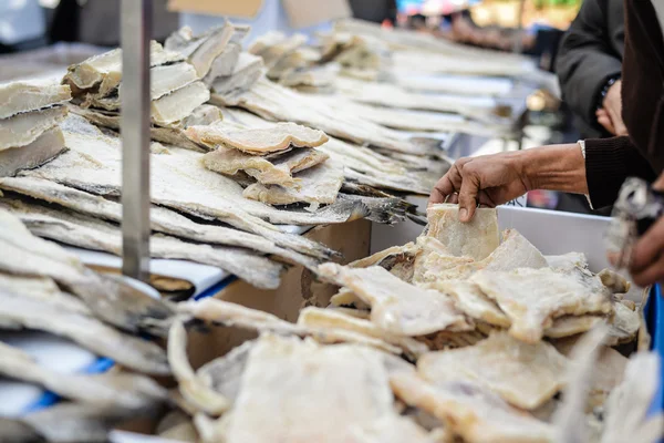 Personne choisissant un filet de morue salé dans un stand de poisson au marché — Photo