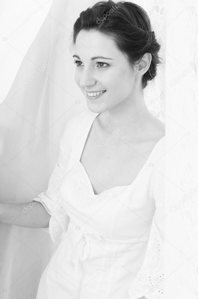Picture of elegant beautiful young lady happy smiling on copy space tulle curtain background. Black and white photography