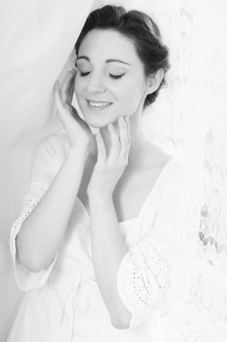 Picture of eyes closed elegant beautiful young lady in white dress happy smiling on copy space tulle curtain background