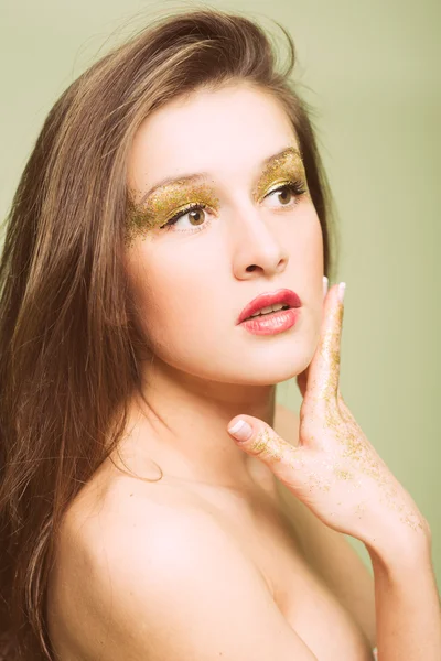 Hermosa mujer joven con maquillaje de ojos dorados y cabello largo —  Fotos de Stock